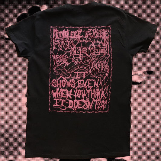 Back view of black t-shirt with pink design. Writes: 'Privilege is like food between your teeth, it shows even when you think it doesn't'