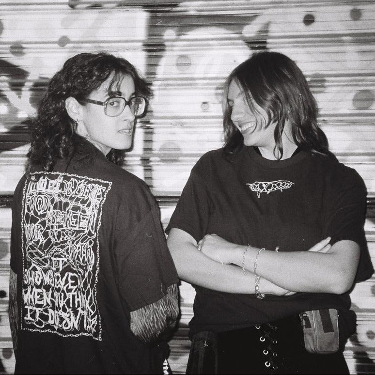 Merch displayed on models, black and white analog picture.