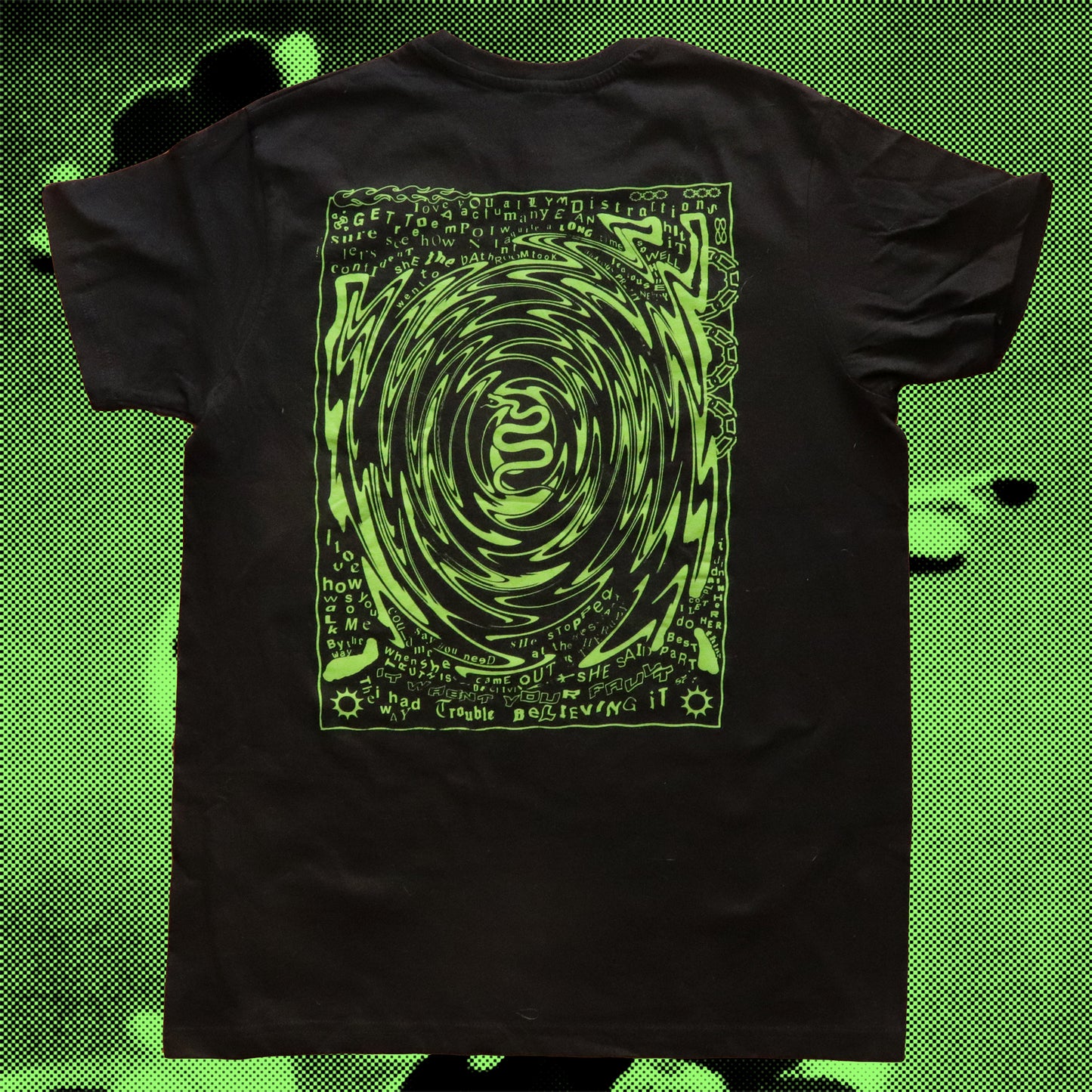 Black t-shirt featuring a neon green hand screen-printed design with swirling artwork and handwritten lyrics from the song ‘FILTH’ on the back.