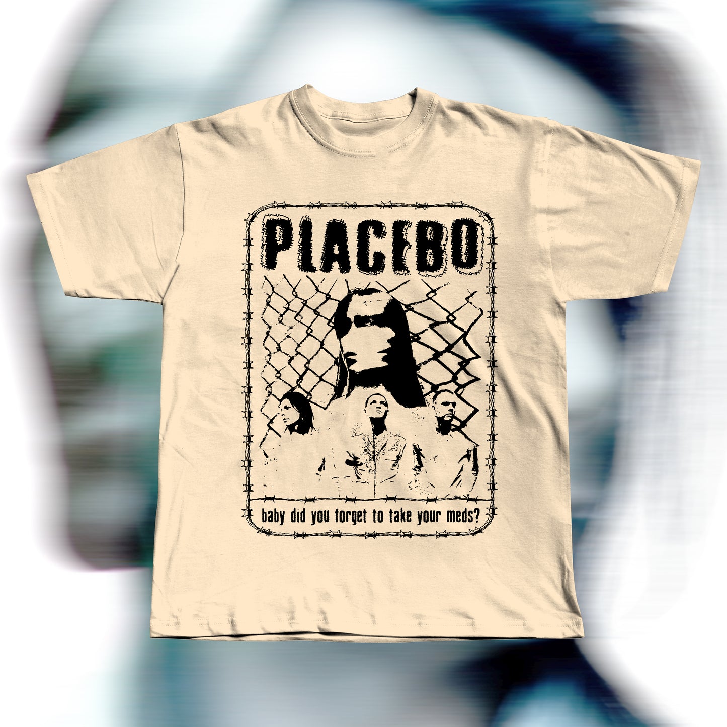 Handmade beige t-shirt featuring purple screen-printed fan art inspired by Placebo. The design shows the band members in front of a chain-link fence with “PLACEBO” written in bold distressed letters and the lyric “baby did you forget to take your meds?” below, surrounded by a barbed-wire border.