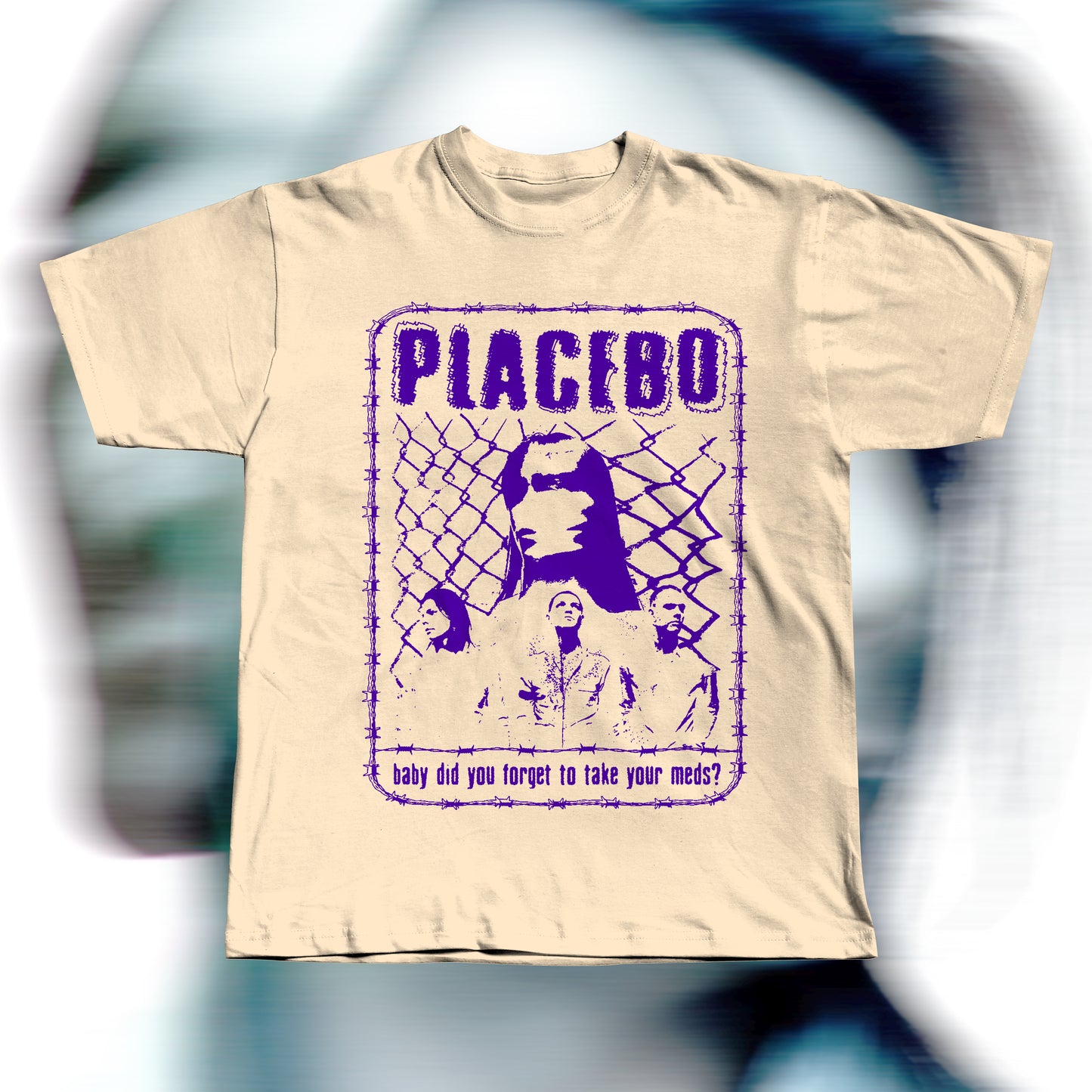 Handmade beige t-shirt featuring purple screen-printed fan art inspired by Placebo. The design shows the band members in front of a chain-link fence with “PLACEBO” written in bold distressed letters and the lyric “baby did you forget to take your meds?” below, surrounded by a barbed-wire border.