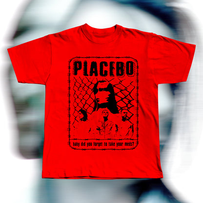 Handmade red t-shirt featuring purple screen-printed fan art inspired by Placebo. The design shows the band members in front of a chain-link fence with “PLACEBO” written in bold distressed letters and the lyric “baby did you forget to take your meds?” below, surrounded by a barbed-wire border.