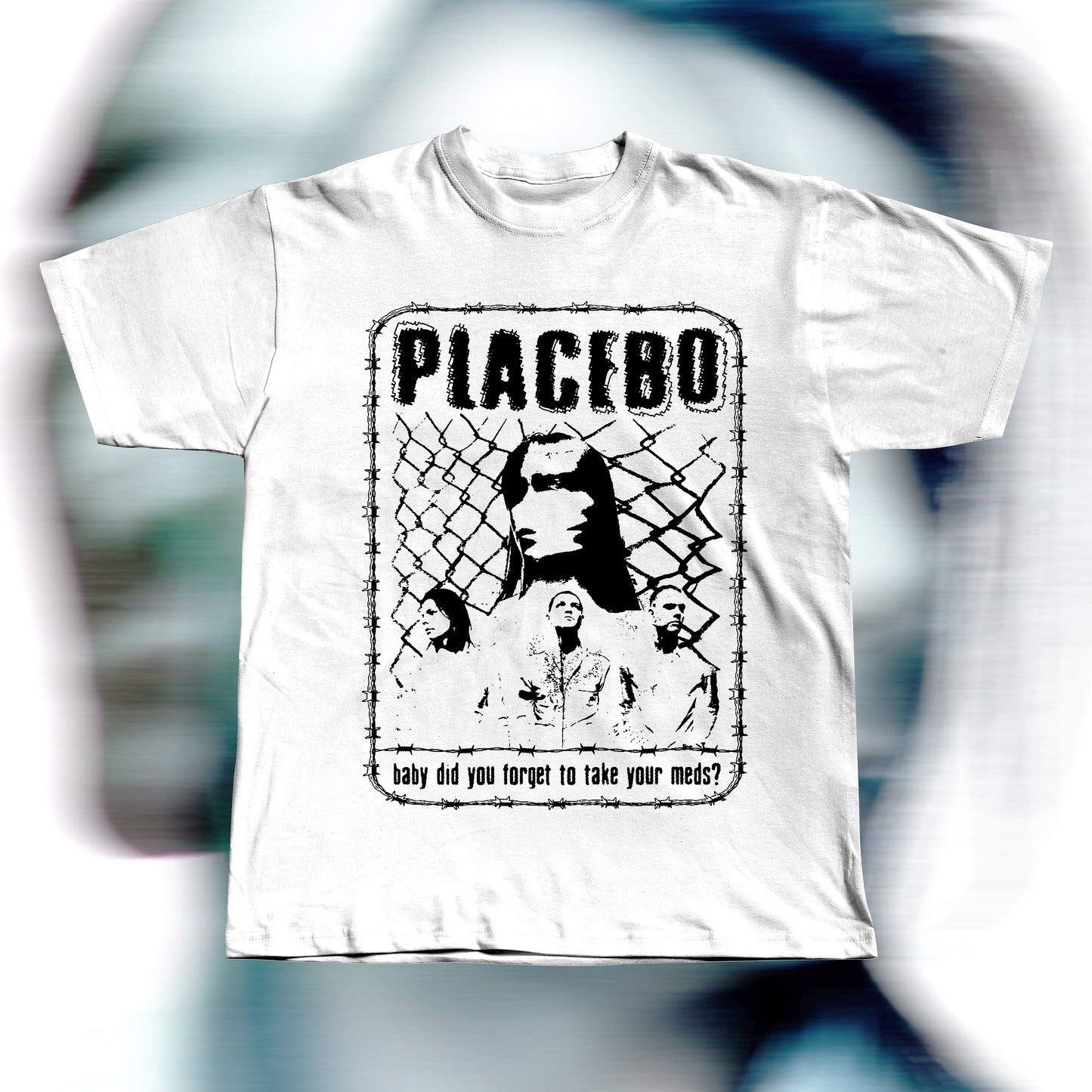 Handmade white t-shirt featuring purple screen-printed fan art inspired by Placebo. The design shows the band members in front of a chain-link fence with “PLACEBO” written in bold distressed letters and the lyric “baby did you forget to take your meds?” below, surrounded by a barbed-wire border.