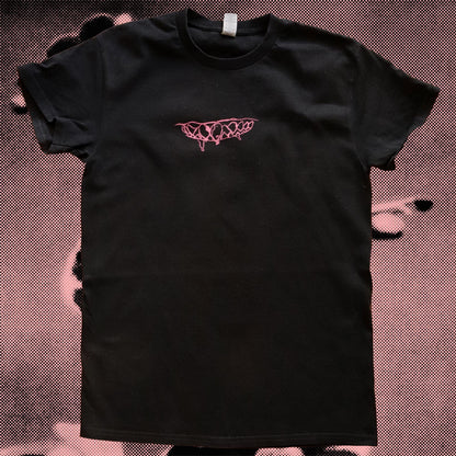 Black t-shirt with pink logo on a textured brown background
