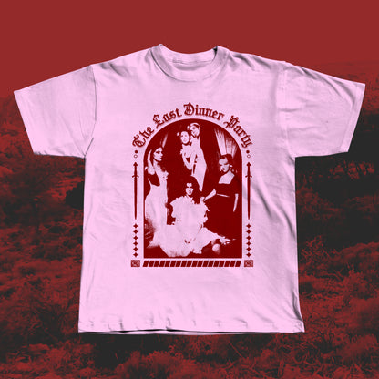 Pink handmade screen-printed T-shirt featuring a red The Last Dinner Party-inspired design with the band in dramatic poses framed by gothic arches and decorative elements.